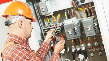 male electrician testing wattage with device