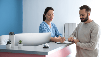 Dental-office-receptionist-reviewing-paperwork-with-patient