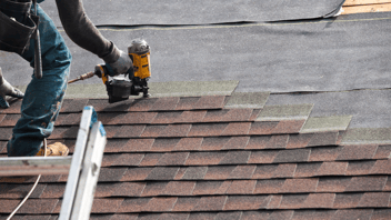Roofer-stapling-shingles-to-house-roof
