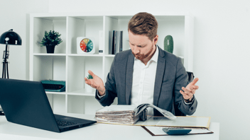 businessman confused by paperwork